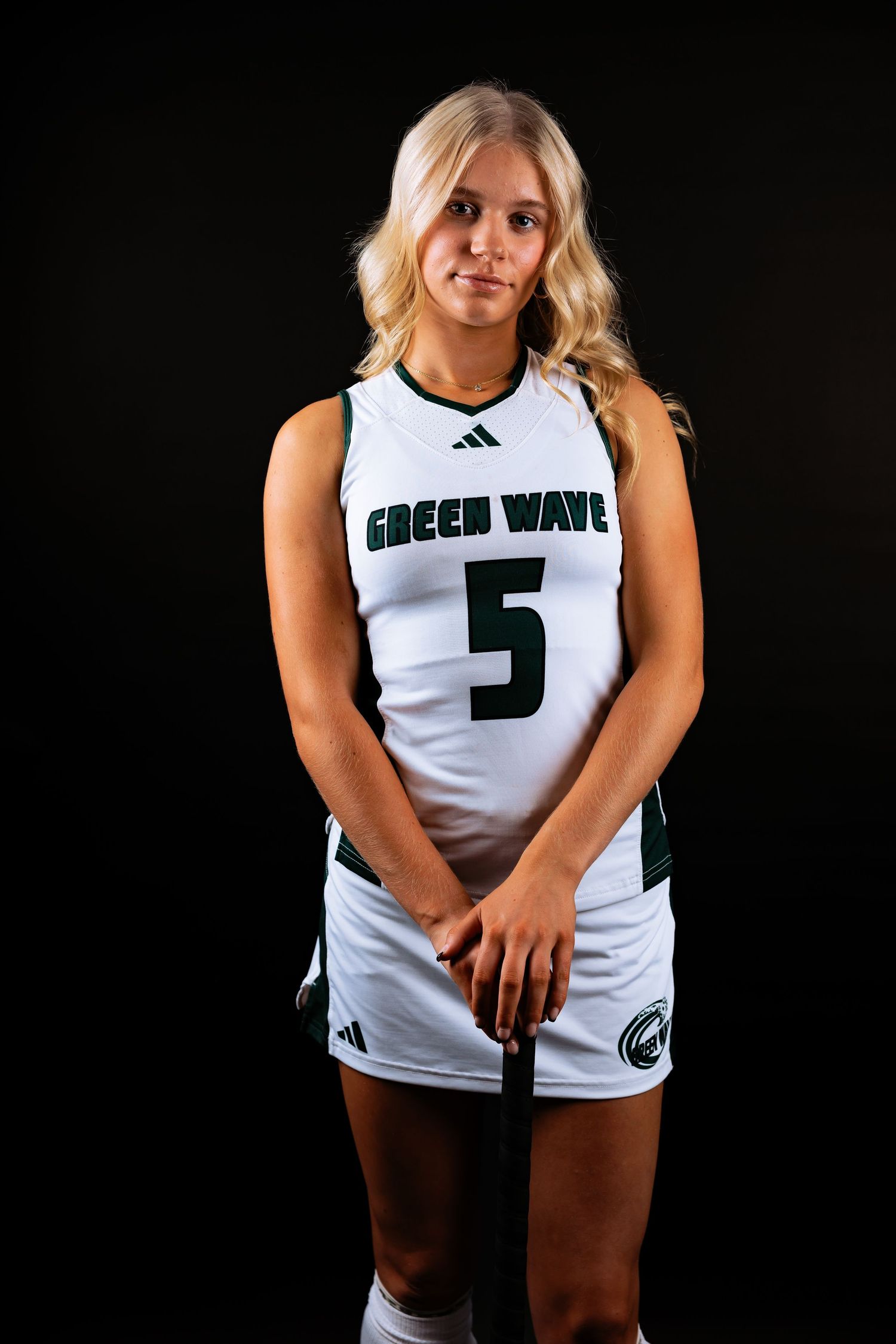 Athletic uniform photoshoot against dark backdrop featuring white jersey with number 5 and Green Wave team branding in Greenfield, Mass.