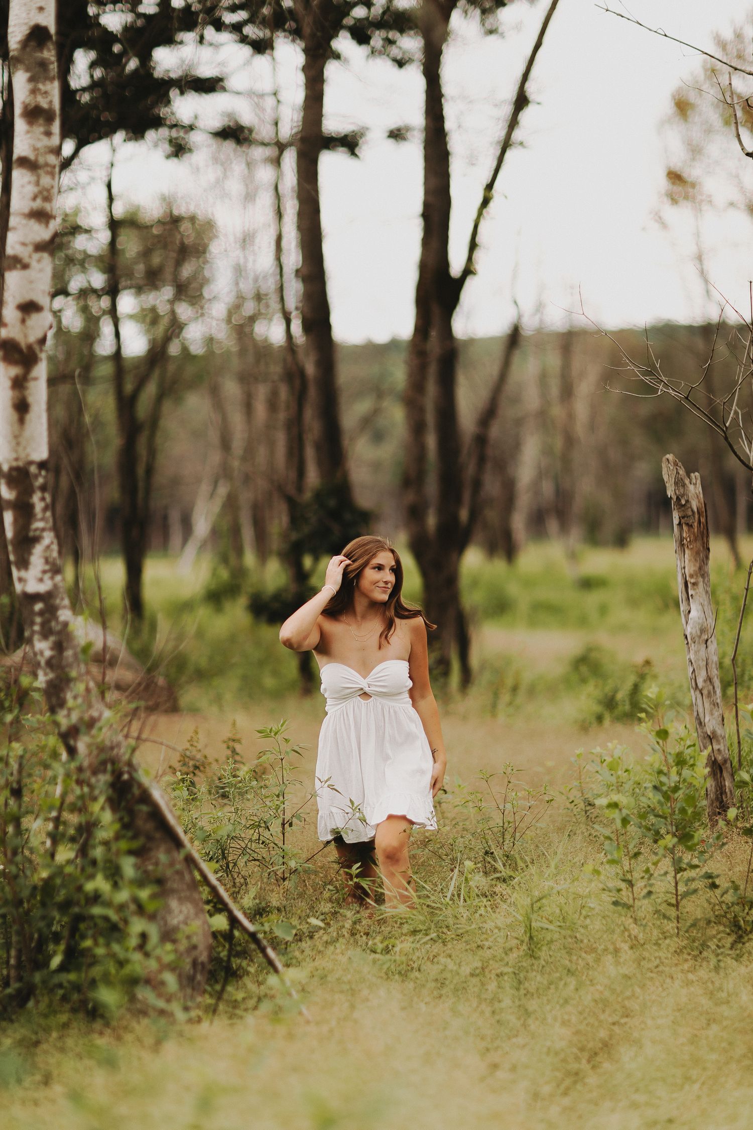 Senior Photoshoot in a dreamy forest setting as sunlight filters through tall trees in a natural woodland scene in Keene, New Hampshire