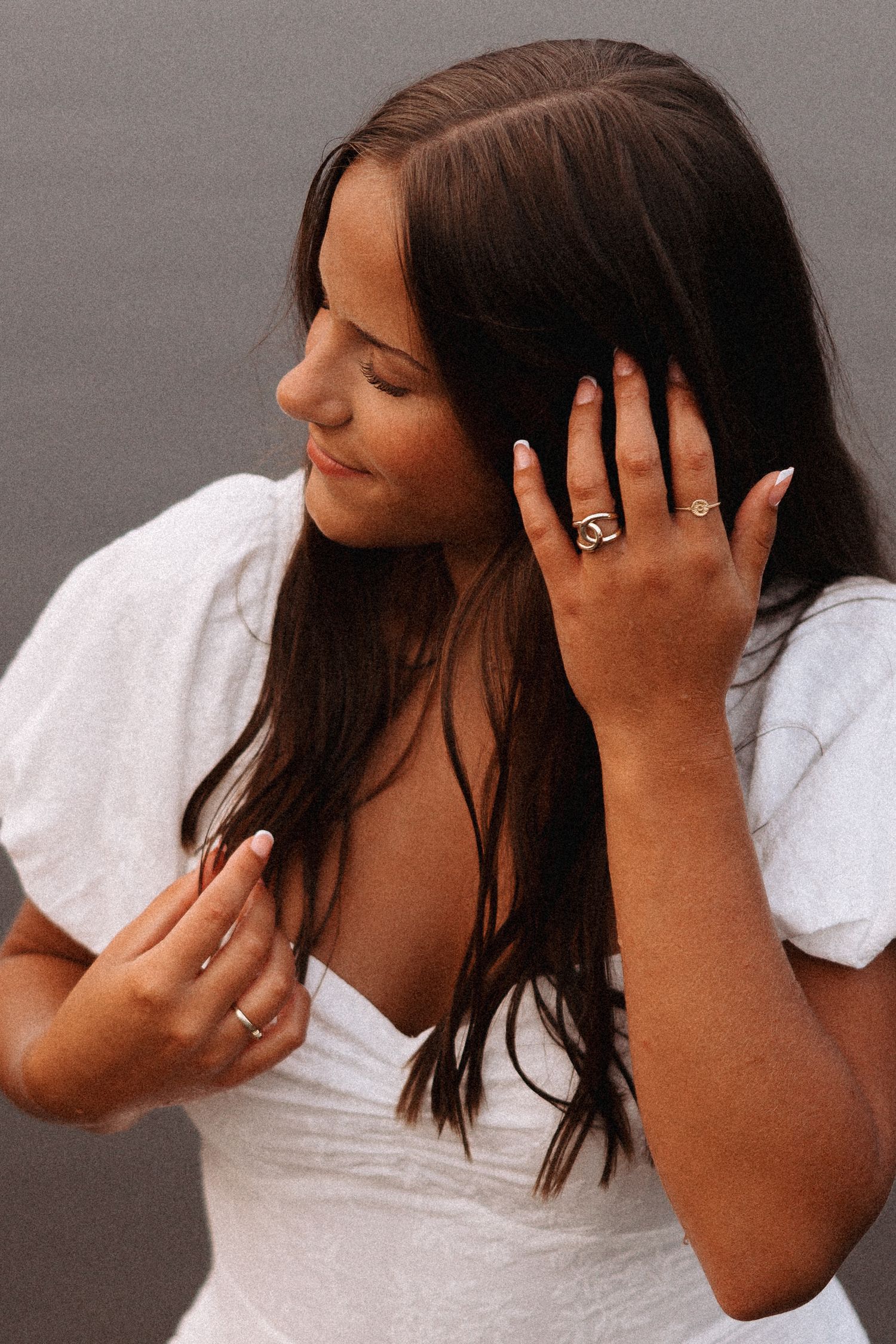 Side profile of a high school senior girl wearing a white dress with long brown hair at Surry Lake in Keene, New Hampshire