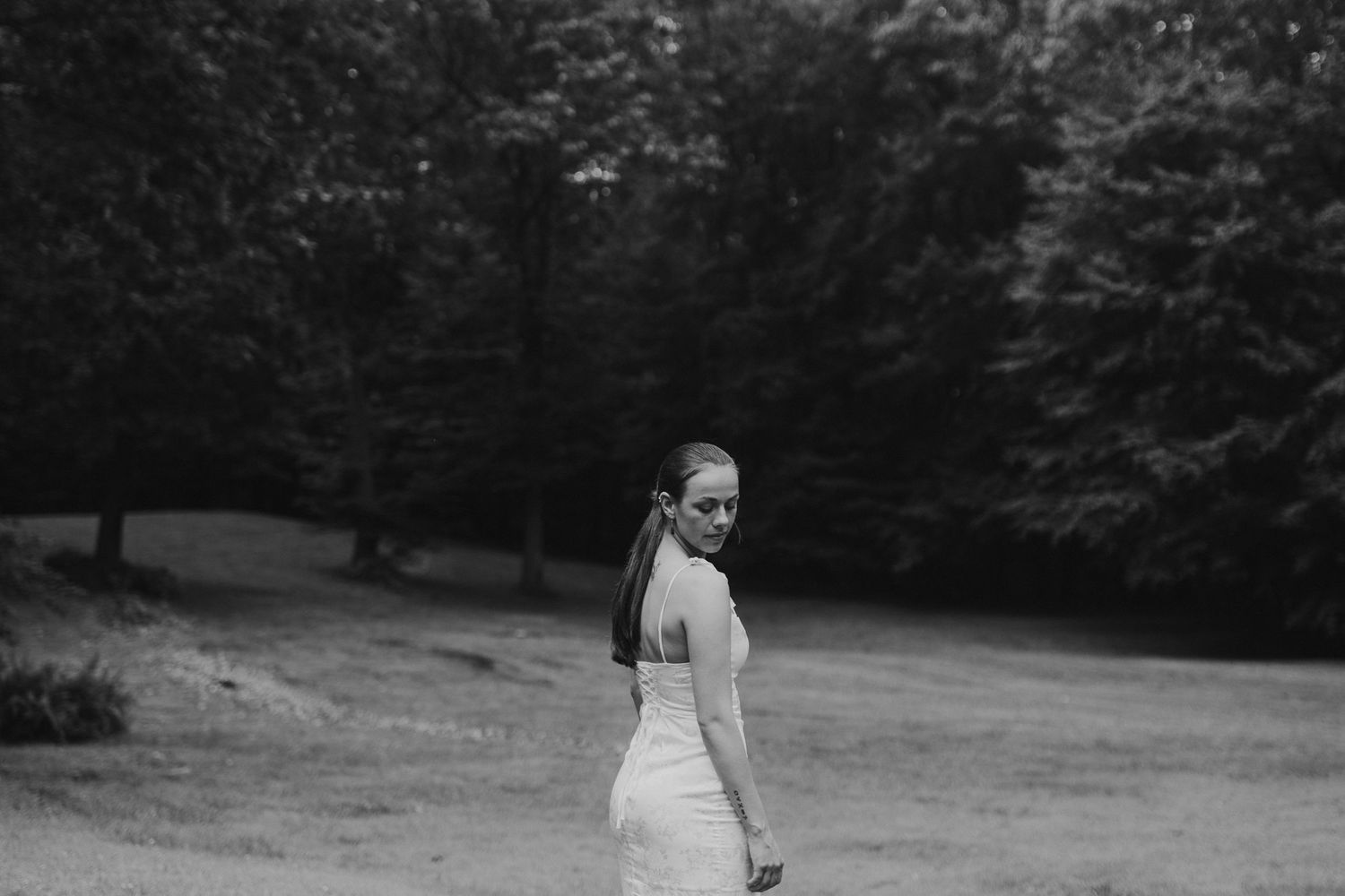 Black and white photography captures peaceful moment on forest path in intimate woodland setting for a new hampshire senior.