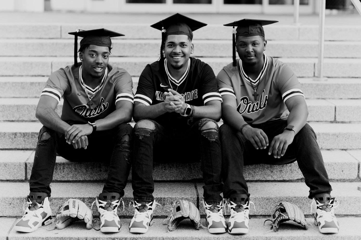 Three athletes sit on a set of white steps, giving the appearance of a triple exposure black and white photograph keene college graduates