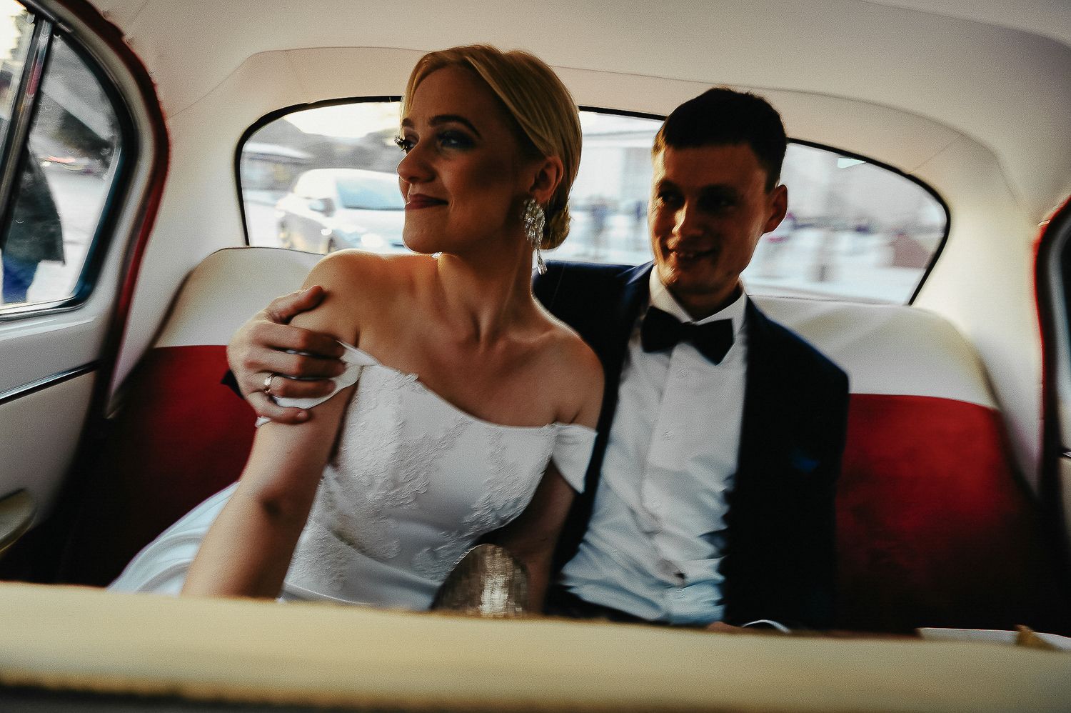 Jaunieji važiuoja automobiliu po vestuvių ceremonijos – dokumentinė vestuvių fotografija