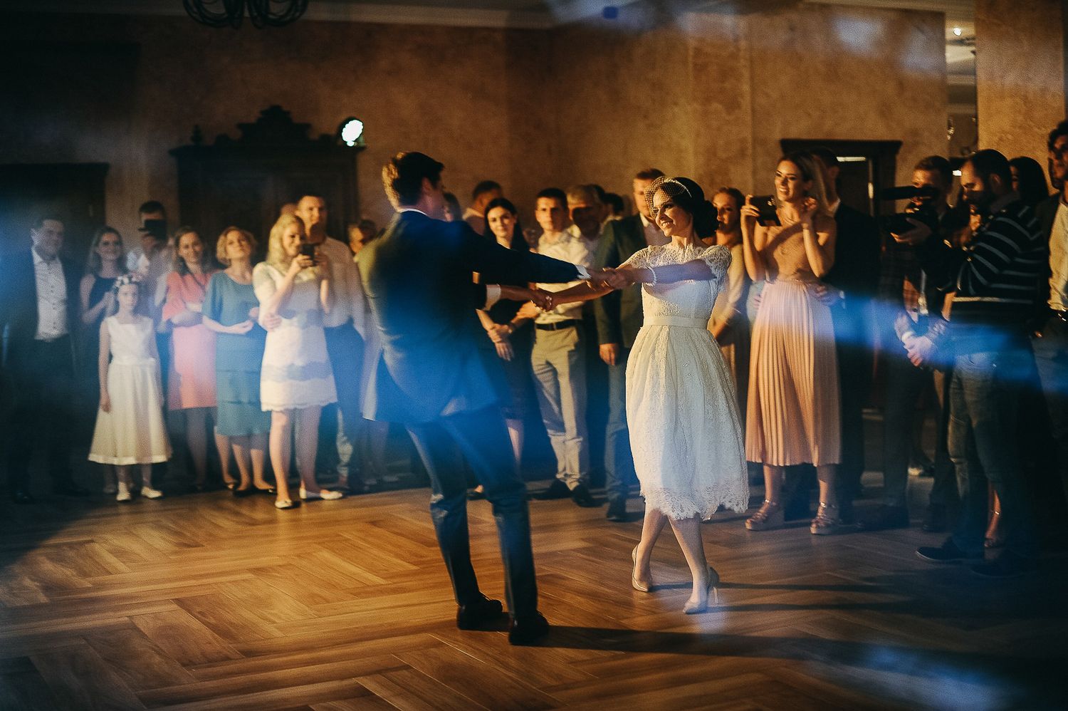 Nuotaka ir jaunikis šoka pirmąjį šokį artimųjų apsuptyje – natūrali vestuvių fotografija