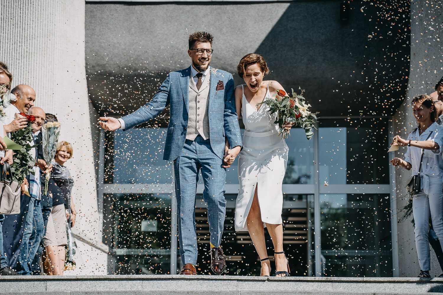 Jaunieji išeina po ceremonijos pasitinkami svečių – dokumentinė vestuvių fotografija