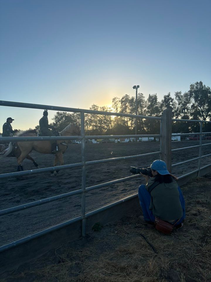 Silhouetted photographer capturing shots at a ranch during sunset.