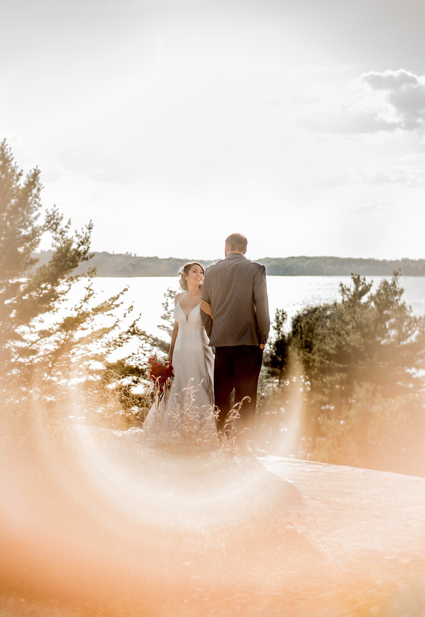 A romantic sunset wedding ceremony silhouetted against a mountain landscape.