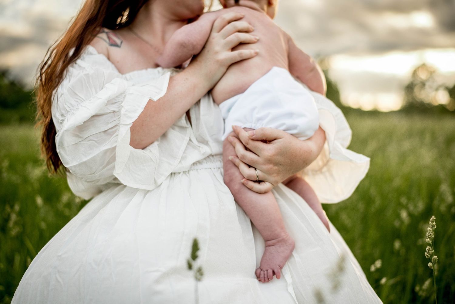 Intimate outdoor photography session featuring white flowing dresses in natural sunlight.