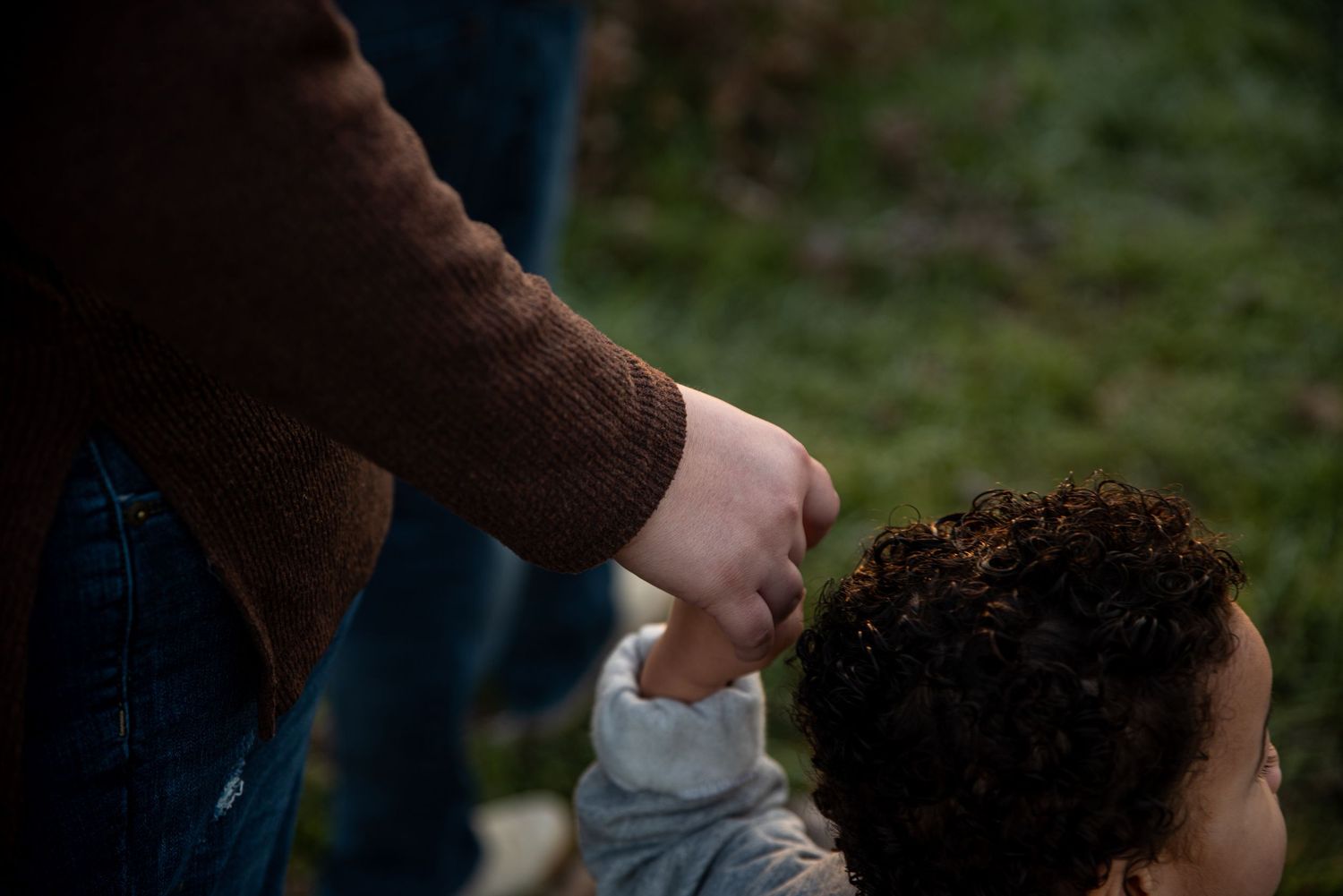 Family enjoying a tender moment together outdoors at dusk.