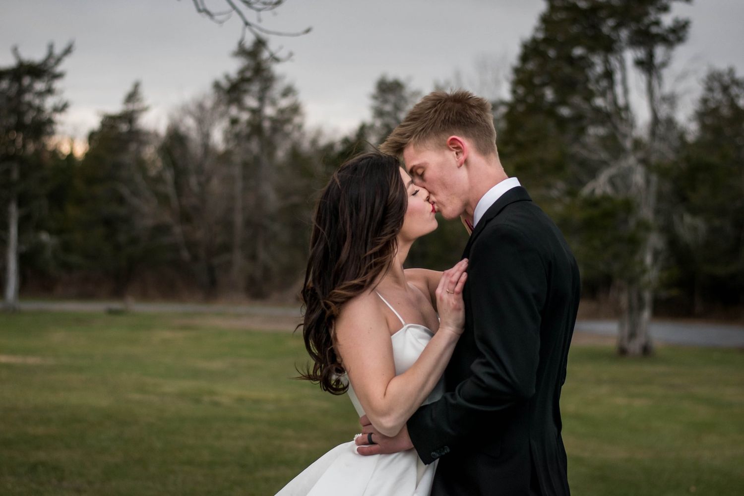 Romantic outdoor wedding photography in an elegant natural setting at dusk.