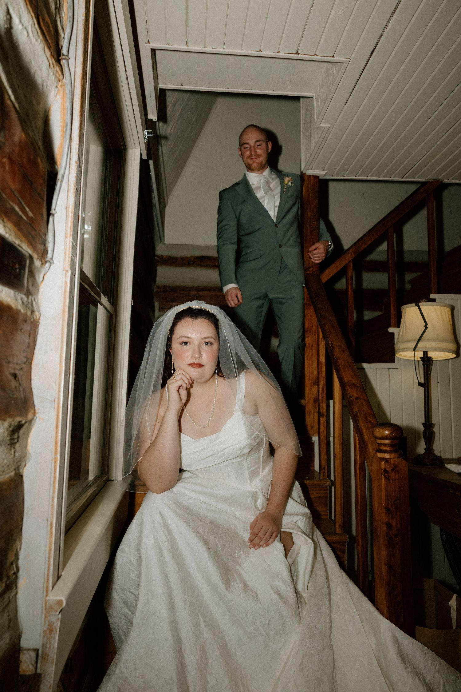 A series of photos showing a bride in a white wedding dress posing on wooden stairs in a rustic indoor setting.