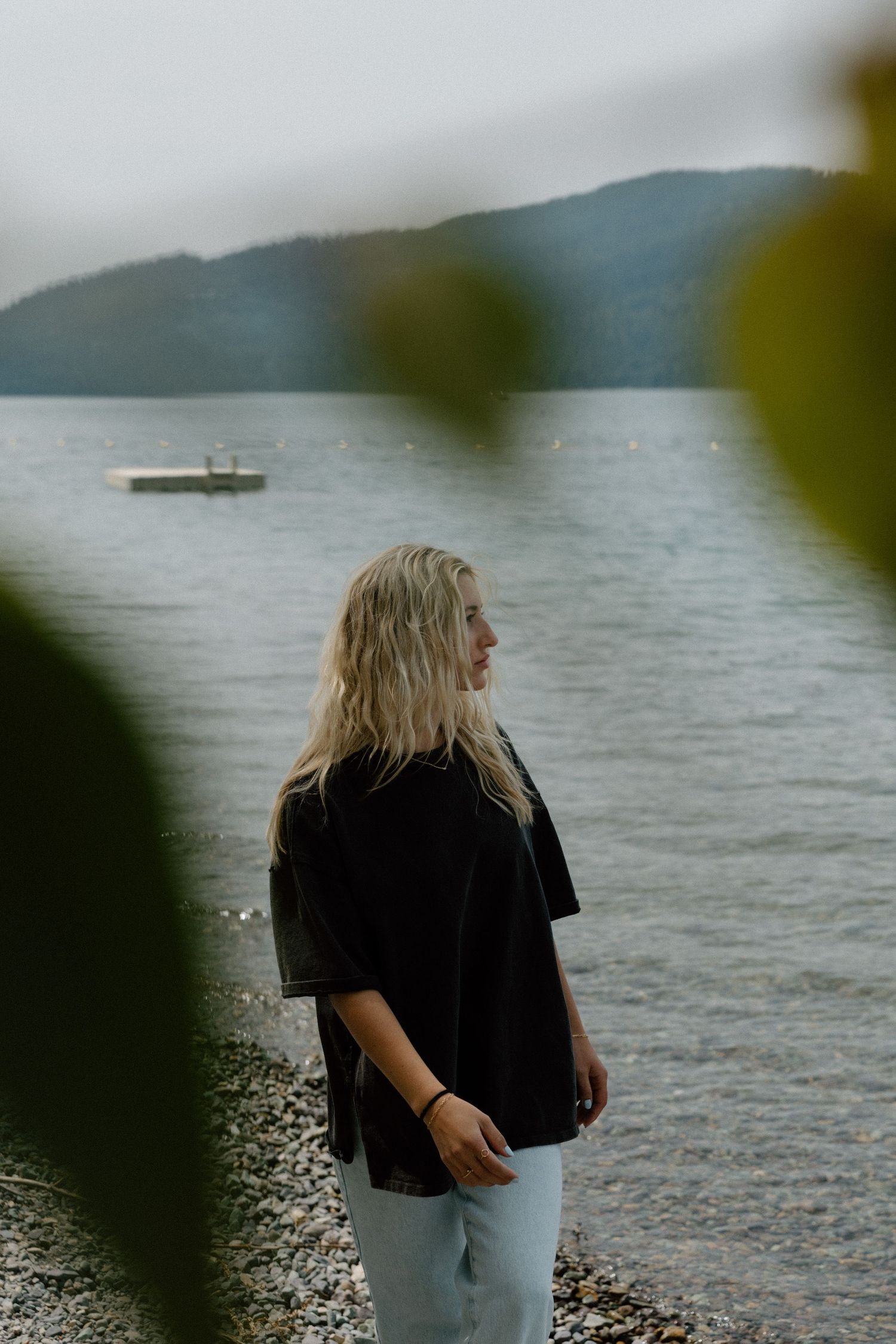 Lakeside portrait with boat and mountains in distance.