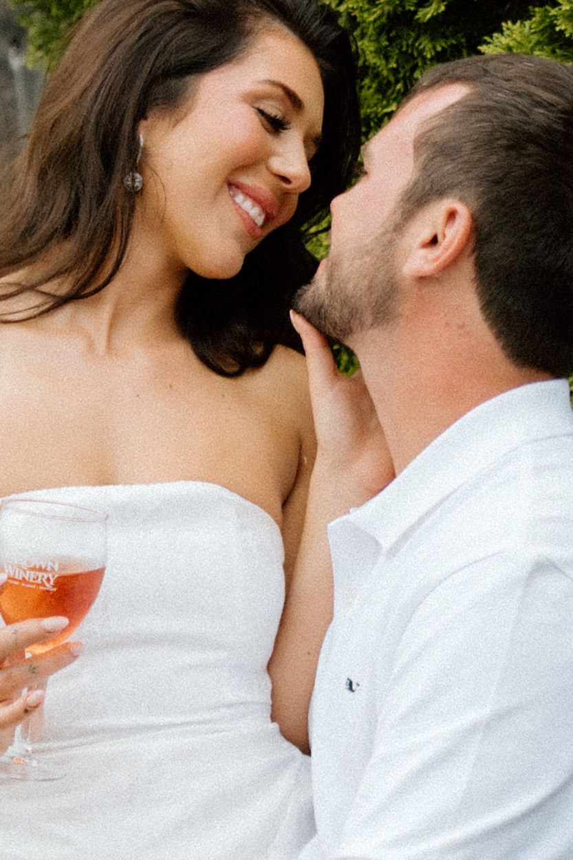 Romantic moment between couple sharing drinks outdoors.