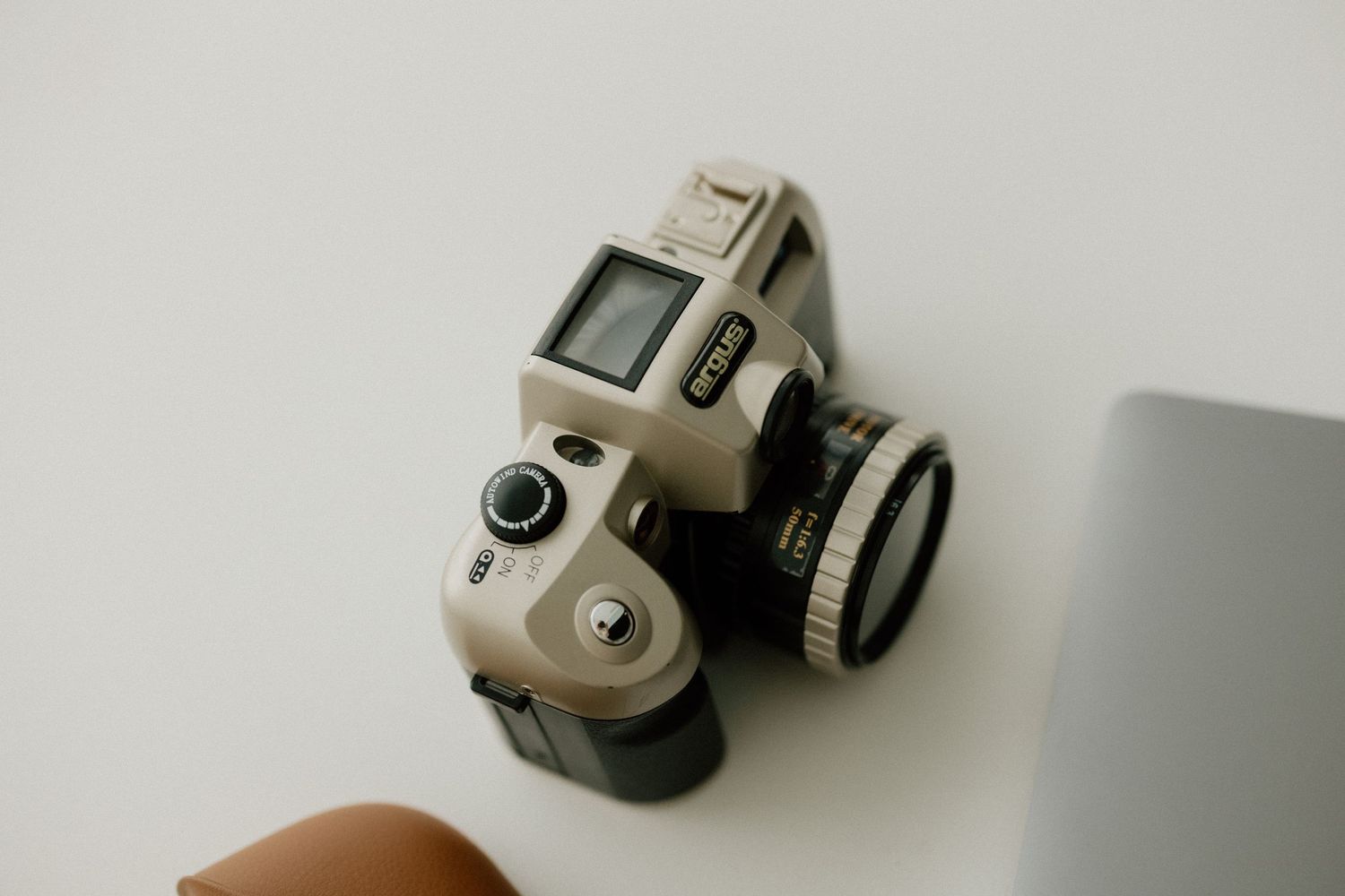 Close-up shot of a vintage-style camera against white background.