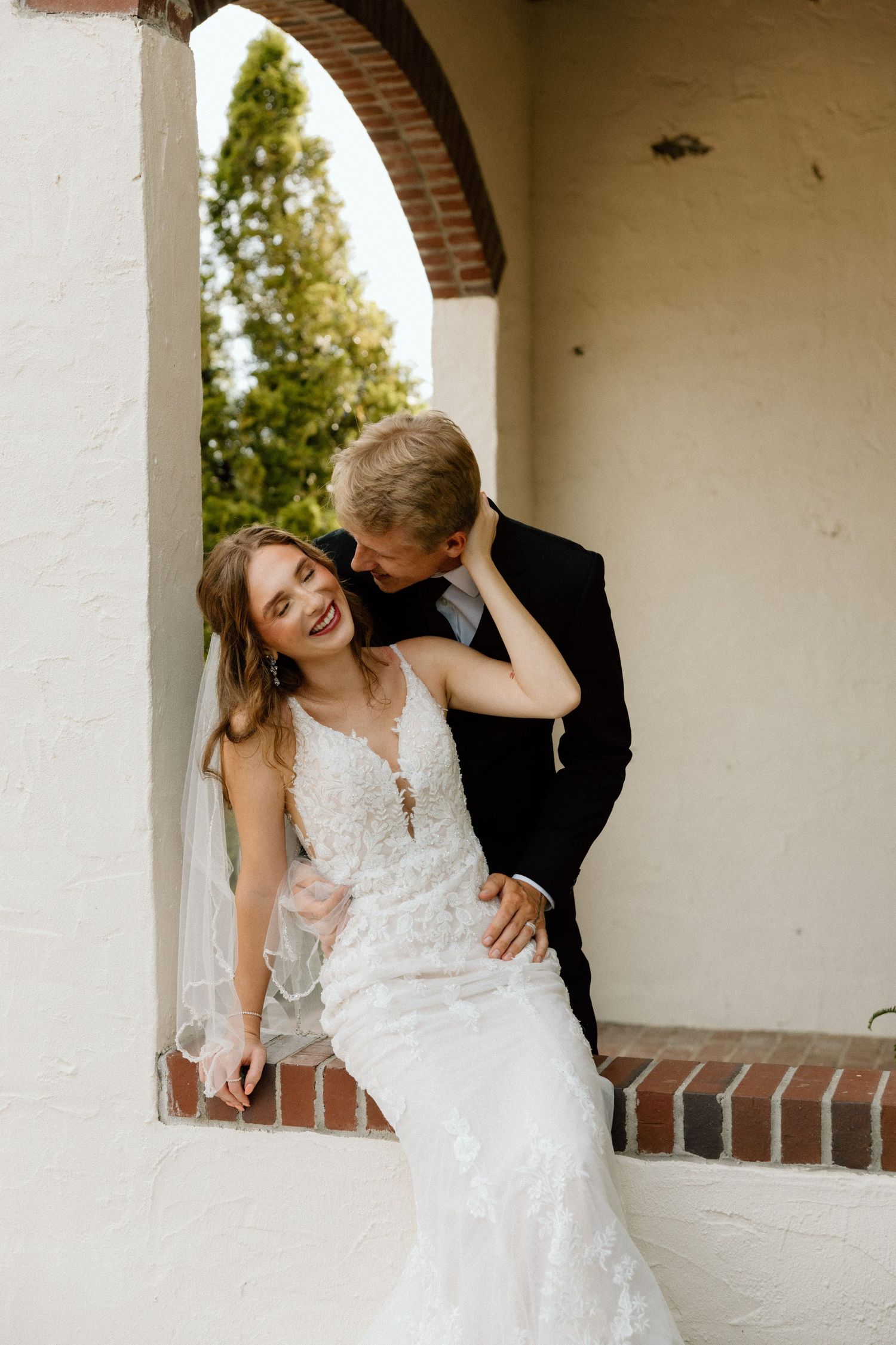 Romantic moment captured under a brick archway.