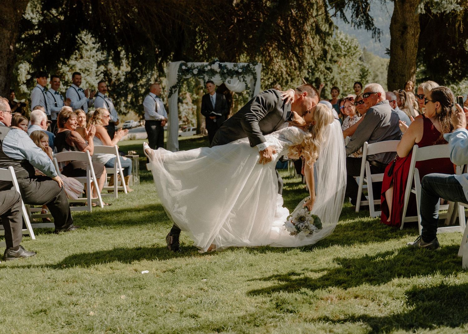 Dip and kiss down the aisle with bride and groom