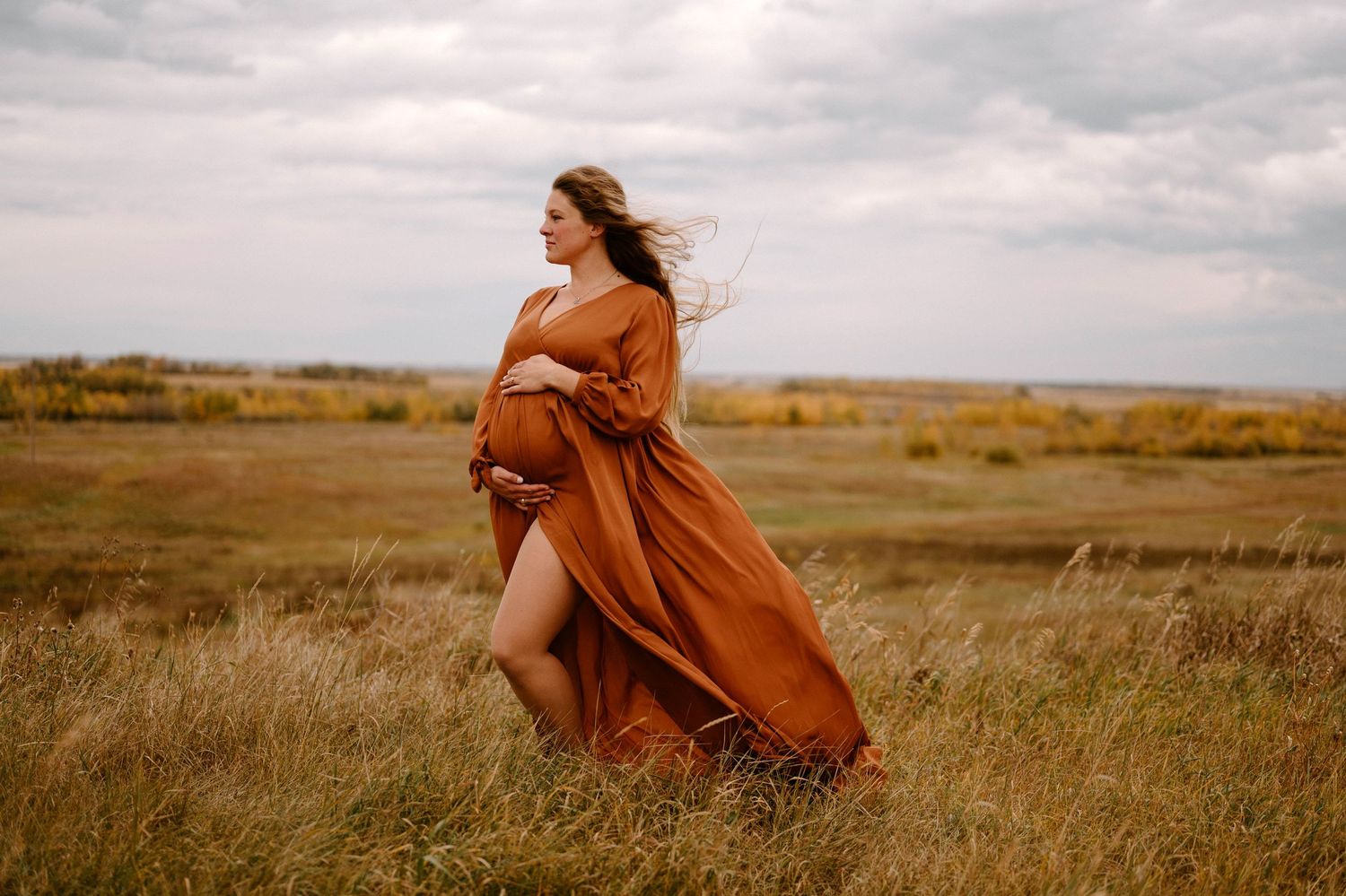 Maternity Session with a mom wearing a burnt orange dress near the Leduc Recreation Center in Leduc Alberta