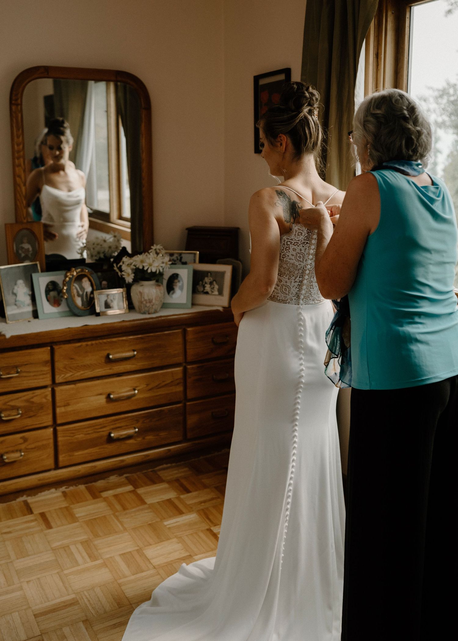 Mother helping daughter into her wedding dress vintage
