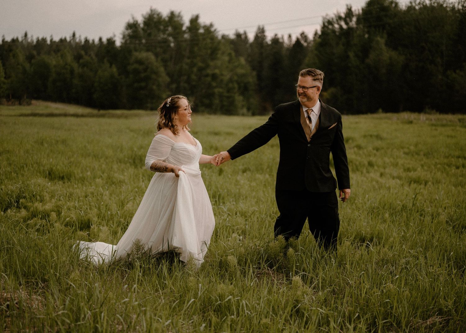 Wedding photo couple walking through grass