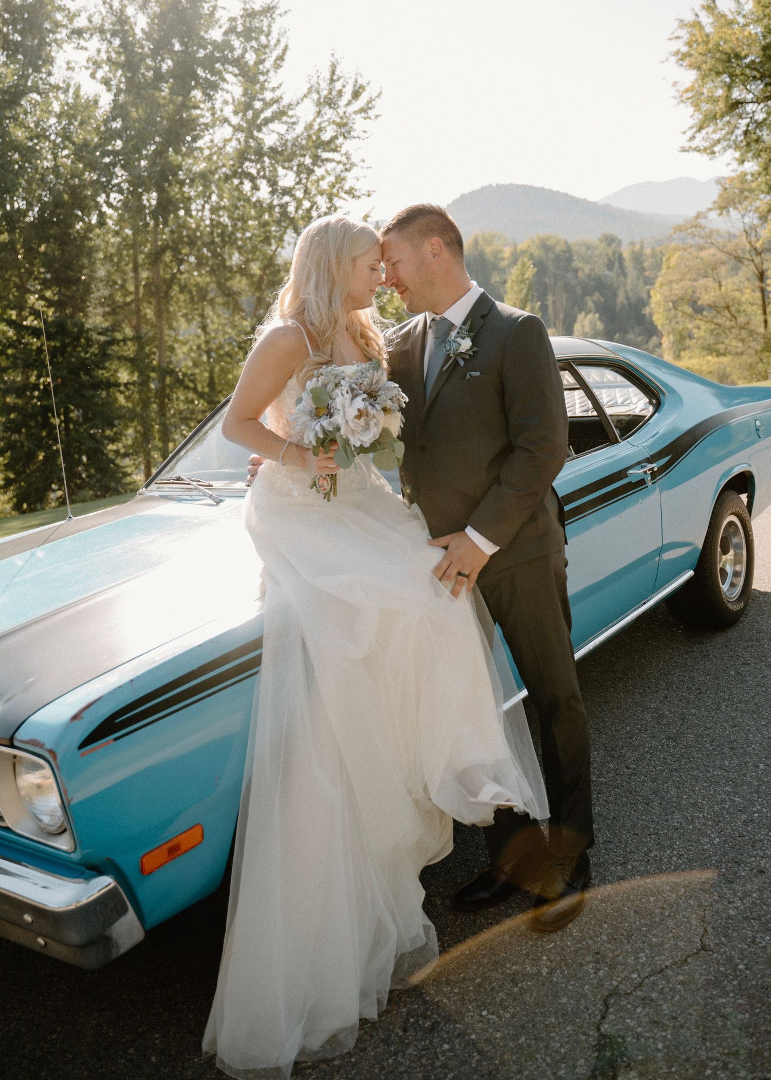 Blonde bride with husband in front of Vintage classic Car