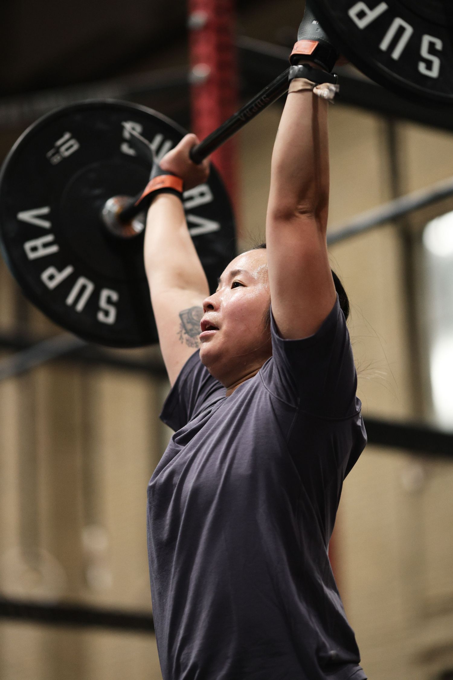 Athlete performing overhead barbell lifts in a sequence of progressive movements in a gym setting.