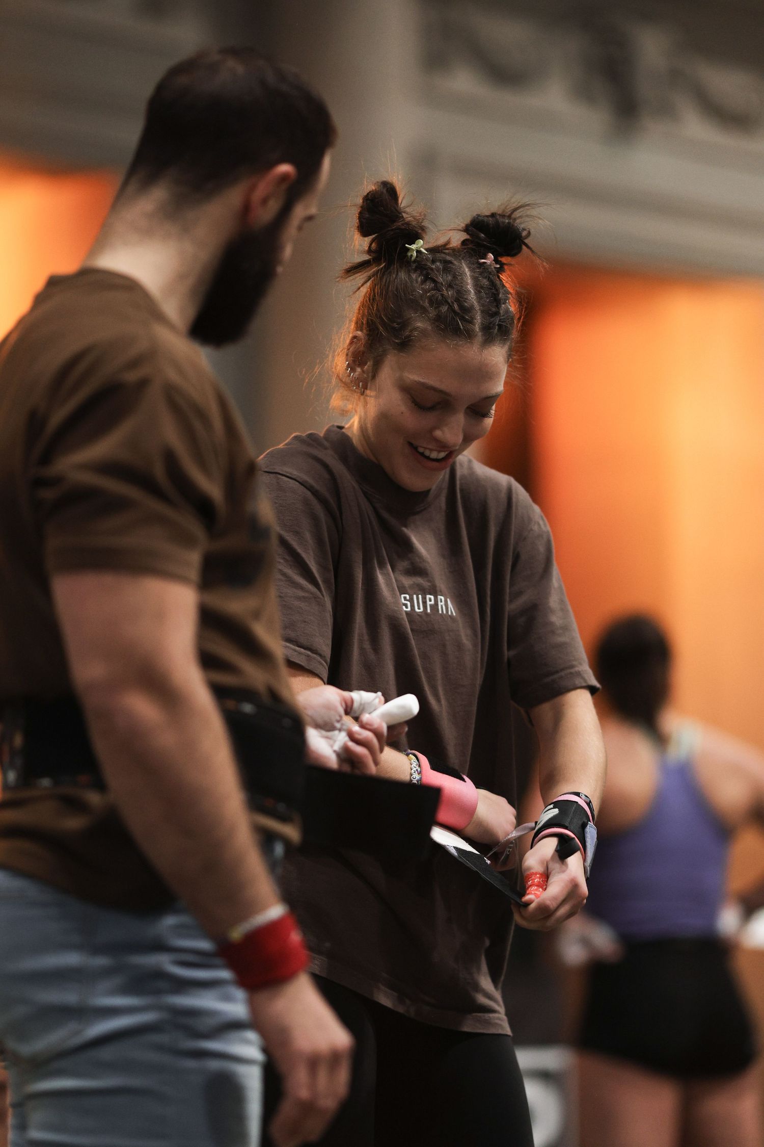 Athletes preparing equipment and reviewing notes during a training session in a fitness facility.