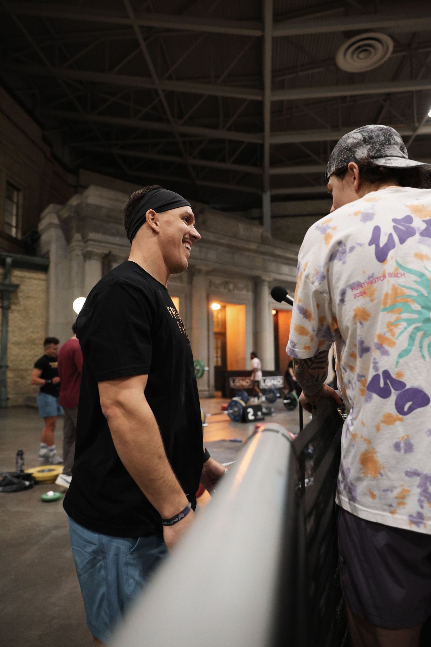 A sequence of four photos showing someone in a black shirt and jeans walking past a person wearing a tie-dye shirt.