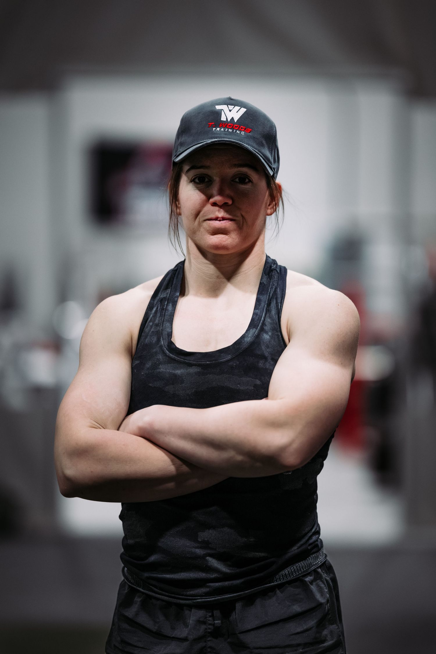 Series of athletic poses showing crossed arms and black tank top against gym background.