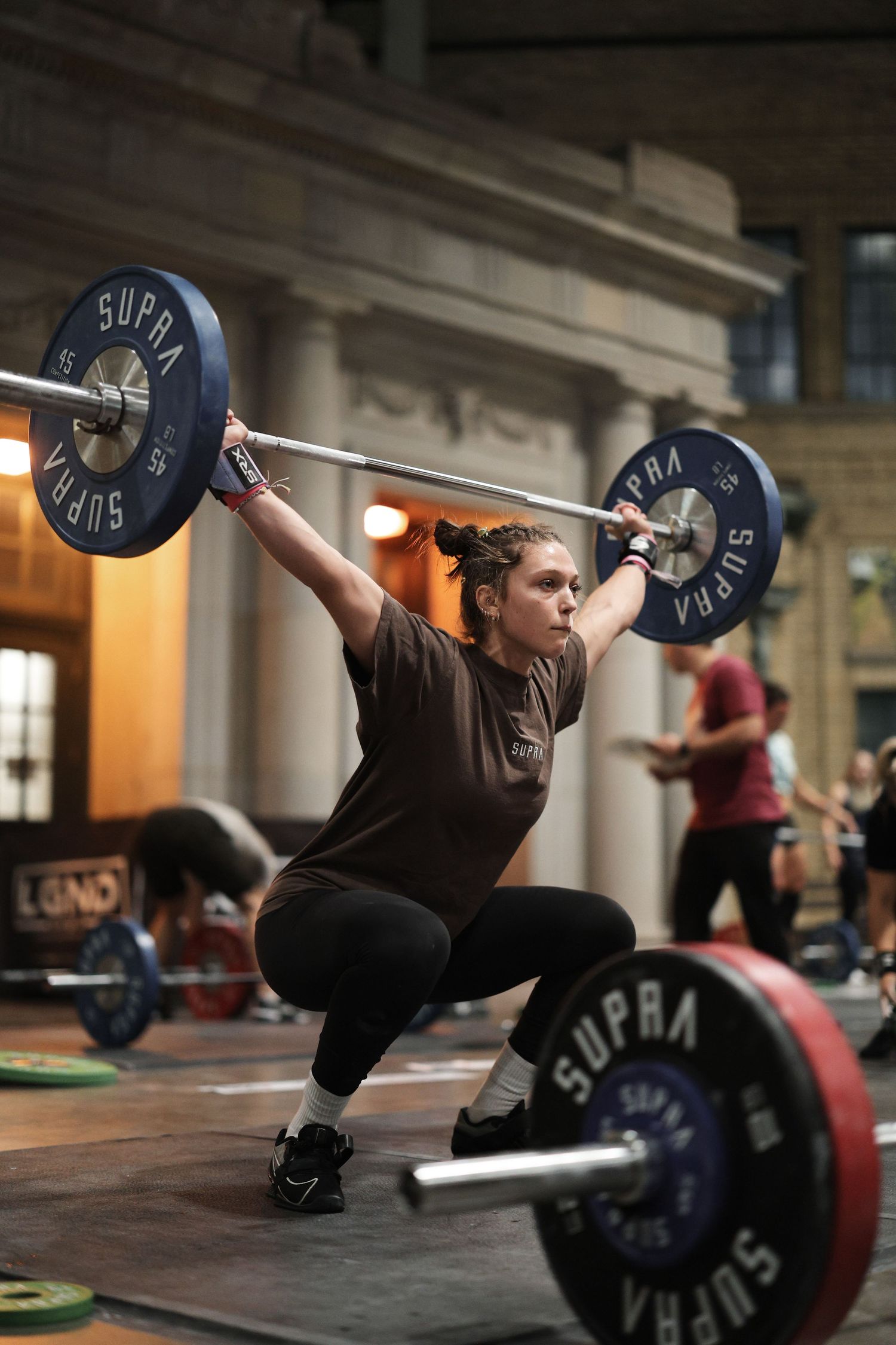 Sequence showing Olympic weightlifting snatch technique progression with barbell in indoor gym setting.