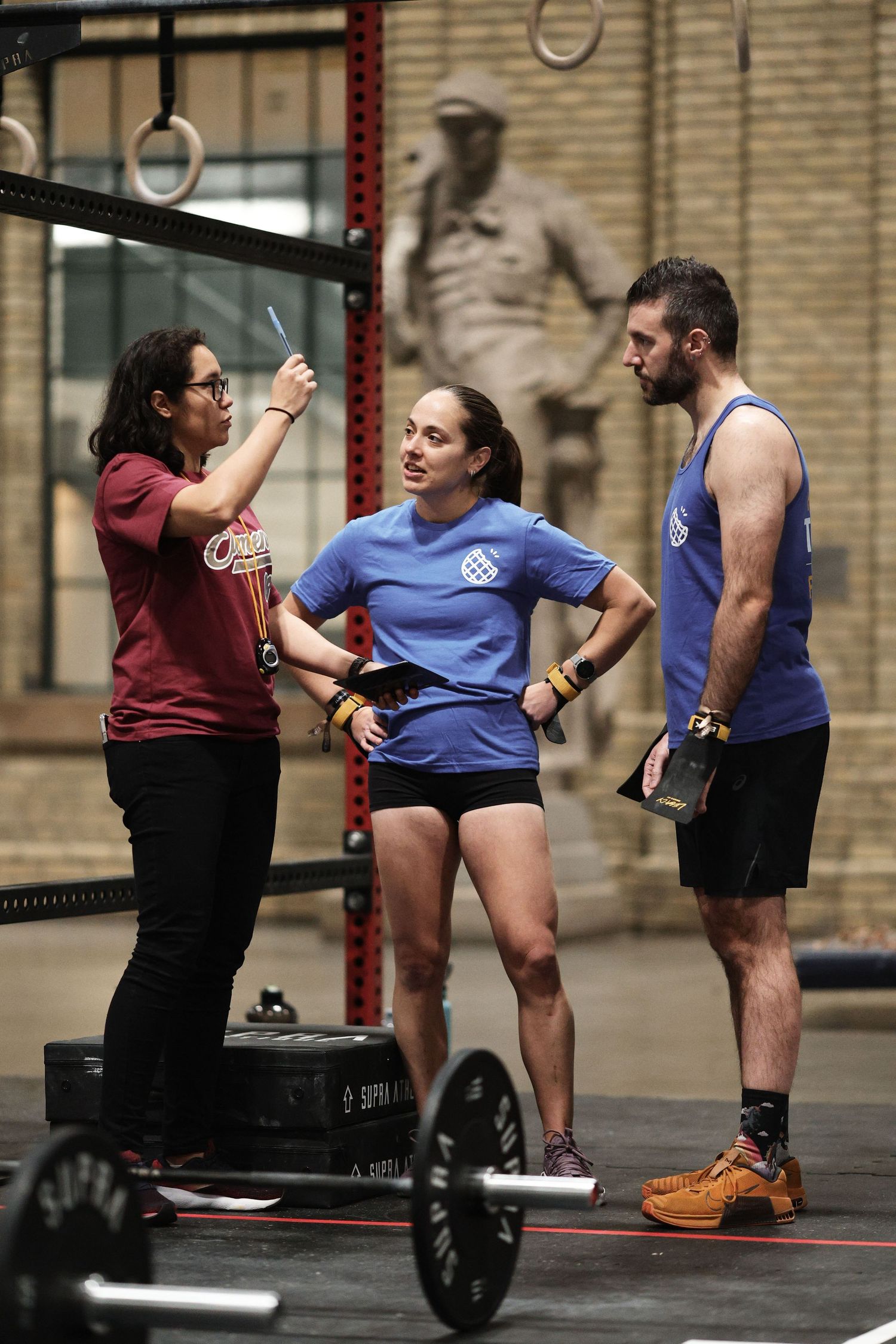 A series of CrossFit athletes perform Olympic weightlifting movements with barbells in a gym setting.