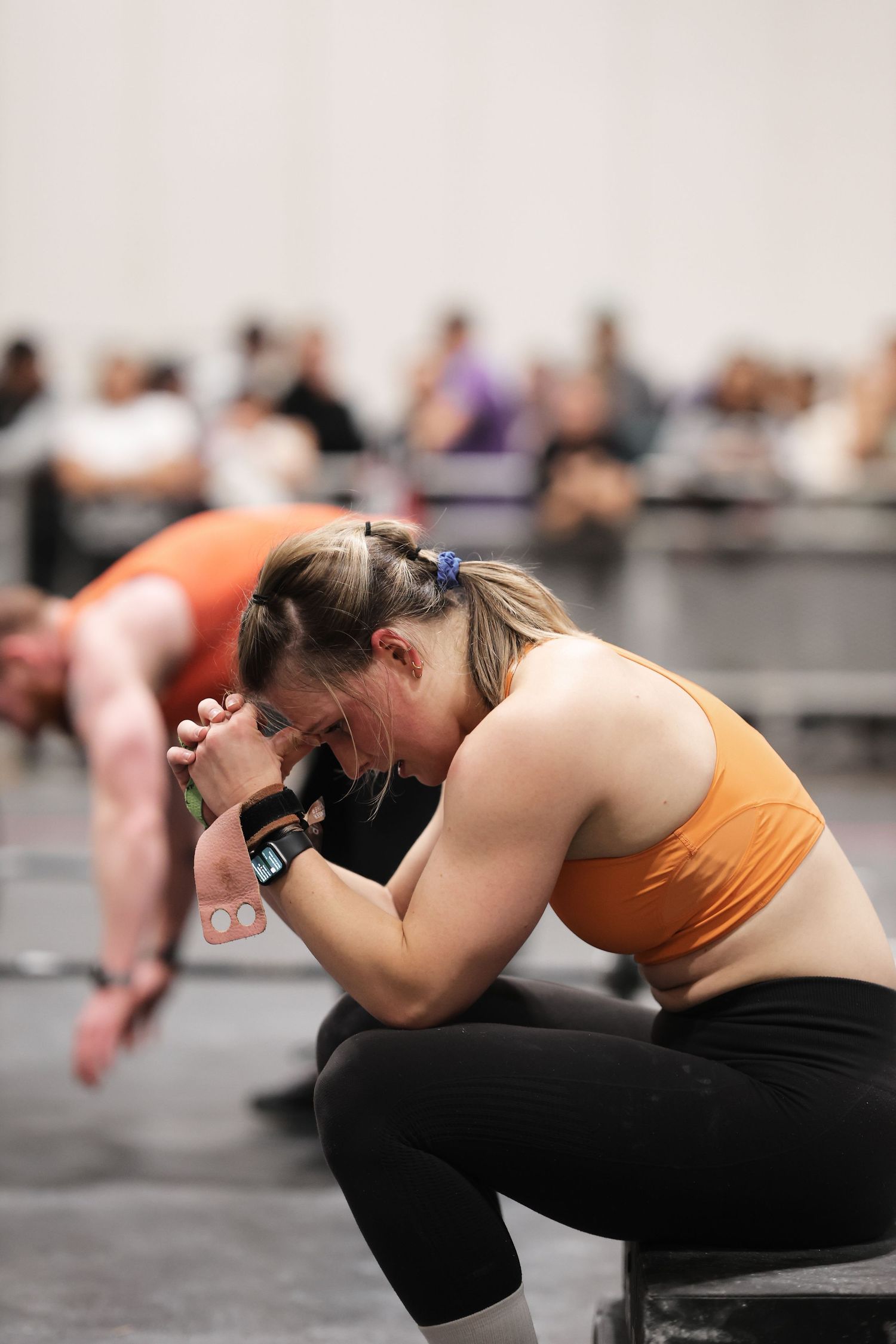 Athletes in a group fitness class performing synchronized stretching exercises on a light colored floor.