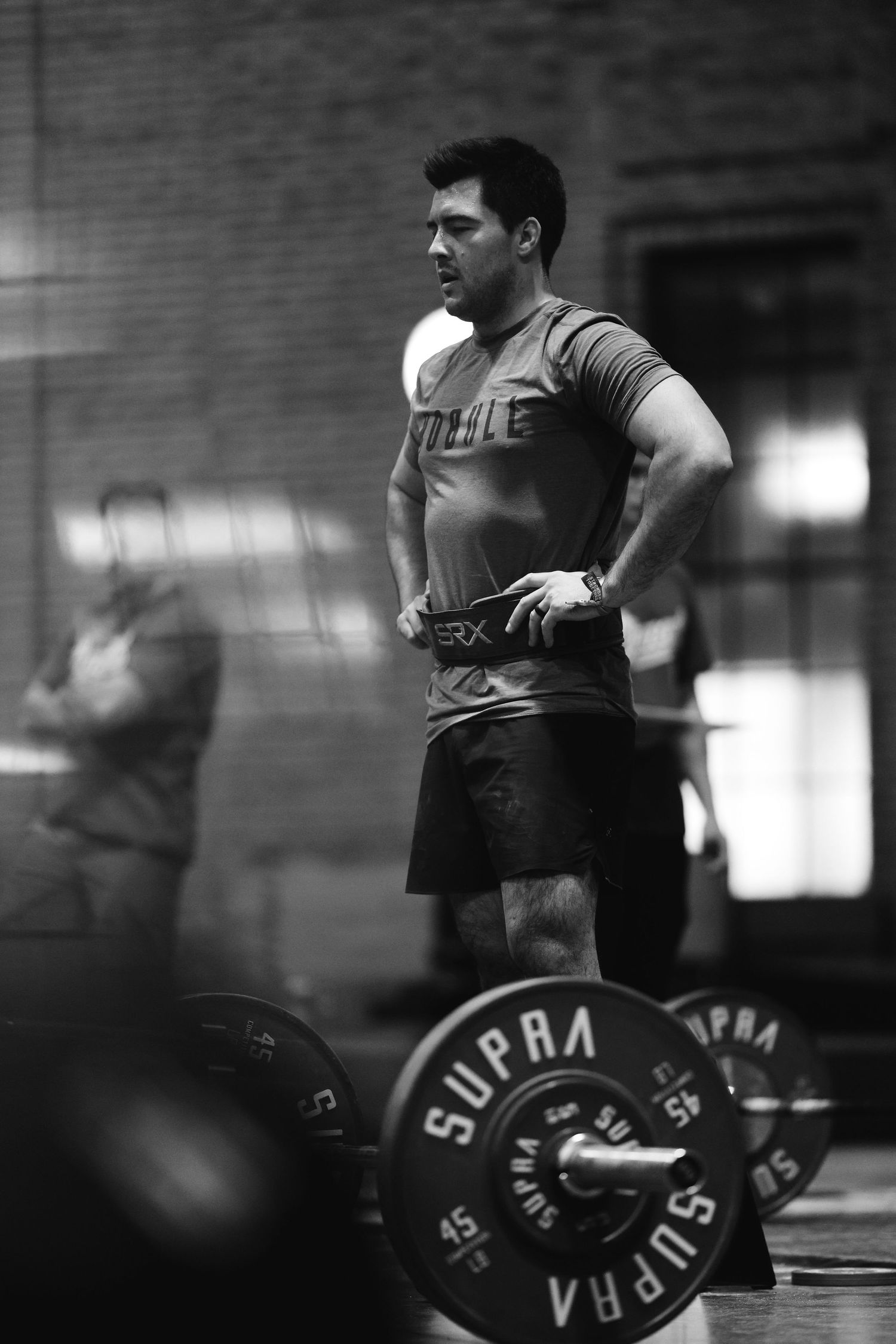 Black and white photos showing weightlifting movements with barbells in a gym setting.