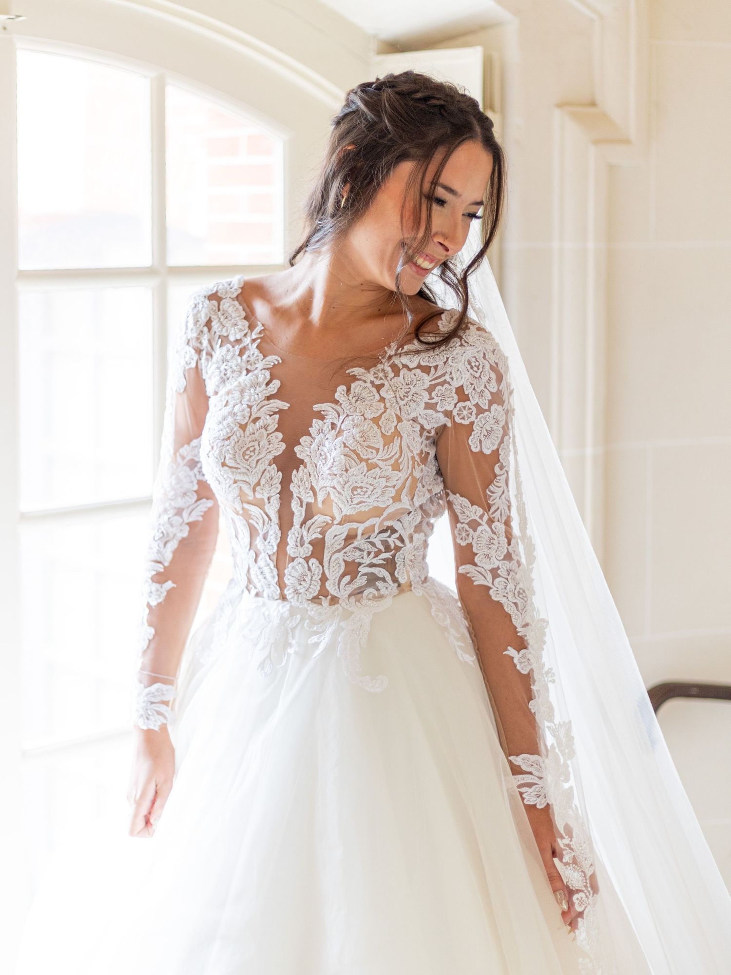 Ethereal wedding dress with sheer lace bodice and flowing tulle skirt captured in natural light.