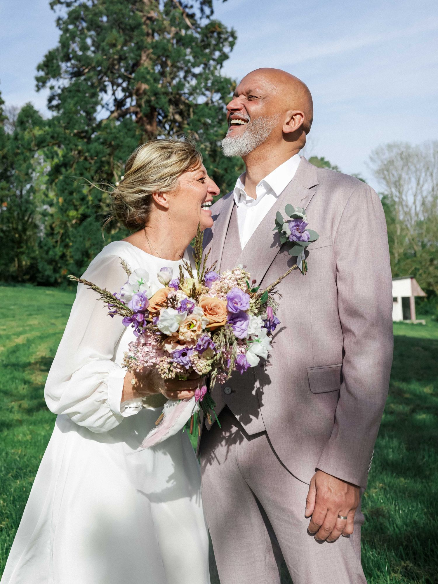 A joyful couple shares tender moments in an outdoor wedding photoshoot with colorful spring flowers.