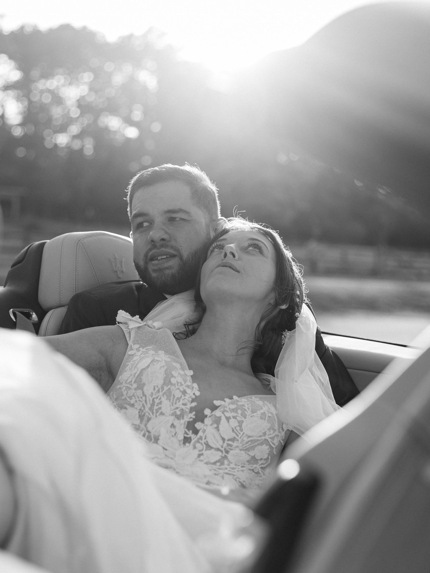 A romantic moment in a convertible car during golden hour.