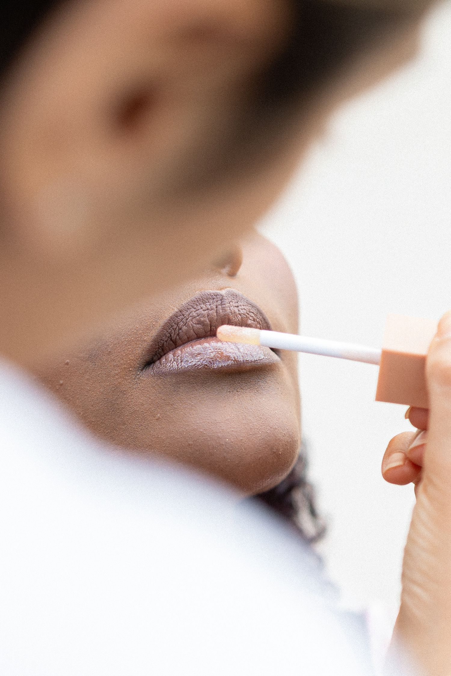 Macro shots showing the application of pink lipstick in sequential frames.