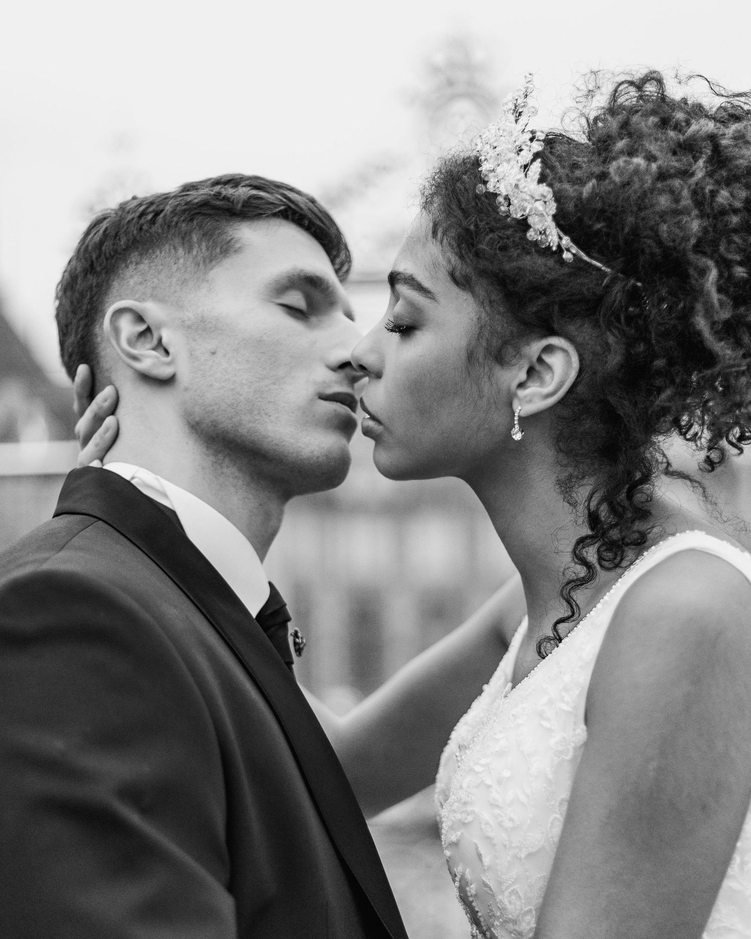 Intimate black and white portrait of a tender wedding kiss.