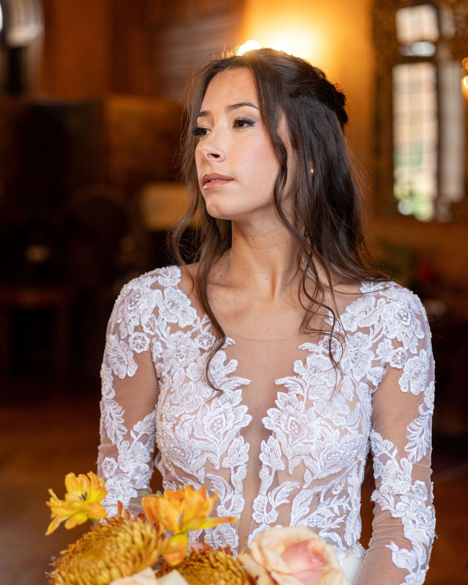 Wedding dress details featuring intricate lace appliques and floral bouquet.