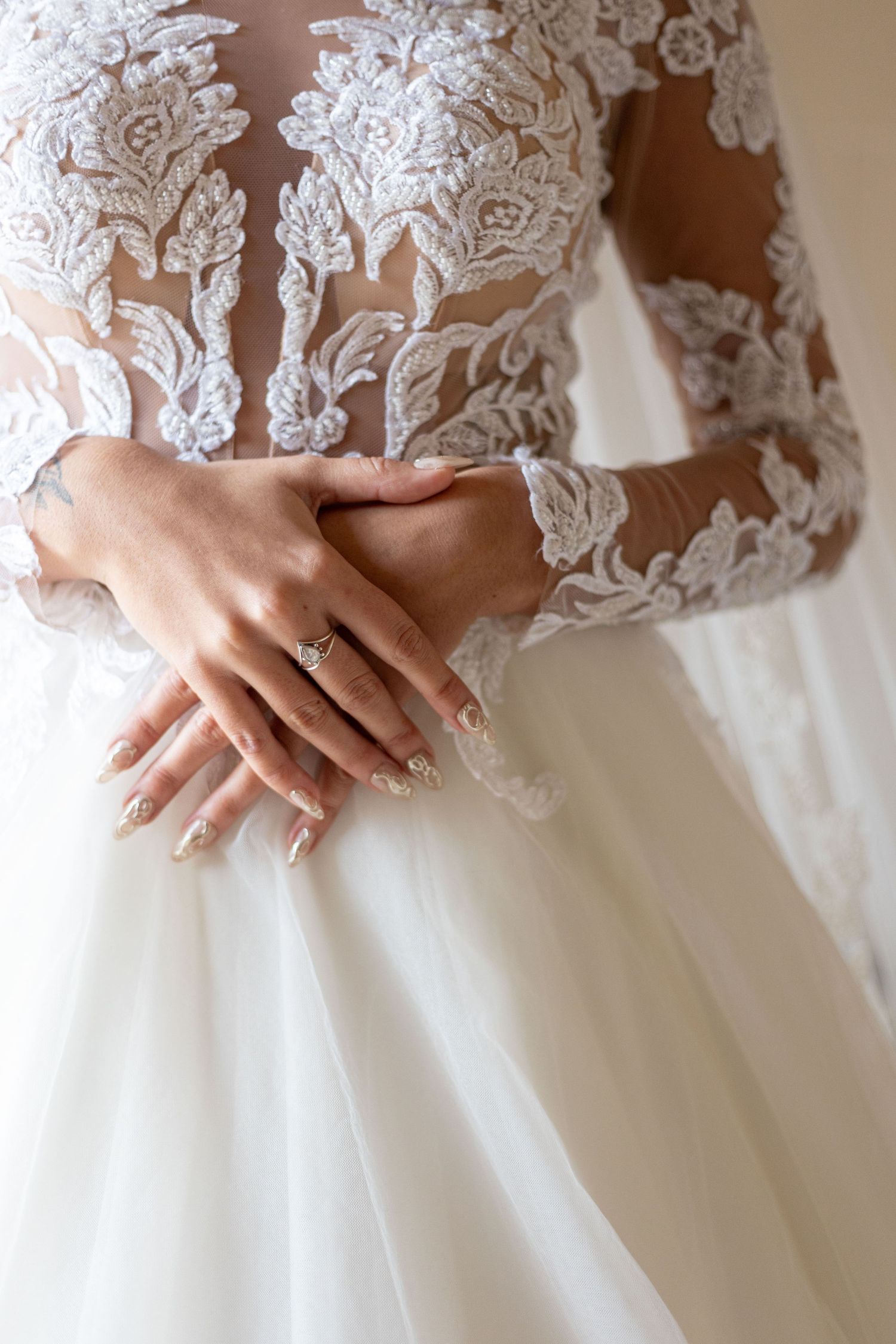 Detailed view of delicate lace appliques and beadwork on a white wedding dress bodice.