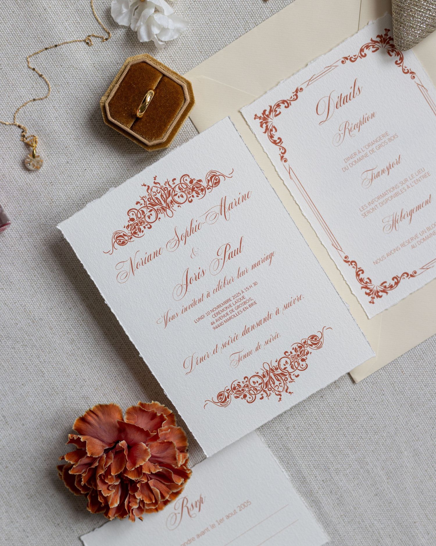 Elegant wedding invitation suite with white cards featuring delicate red floral designs and calligraphy details.