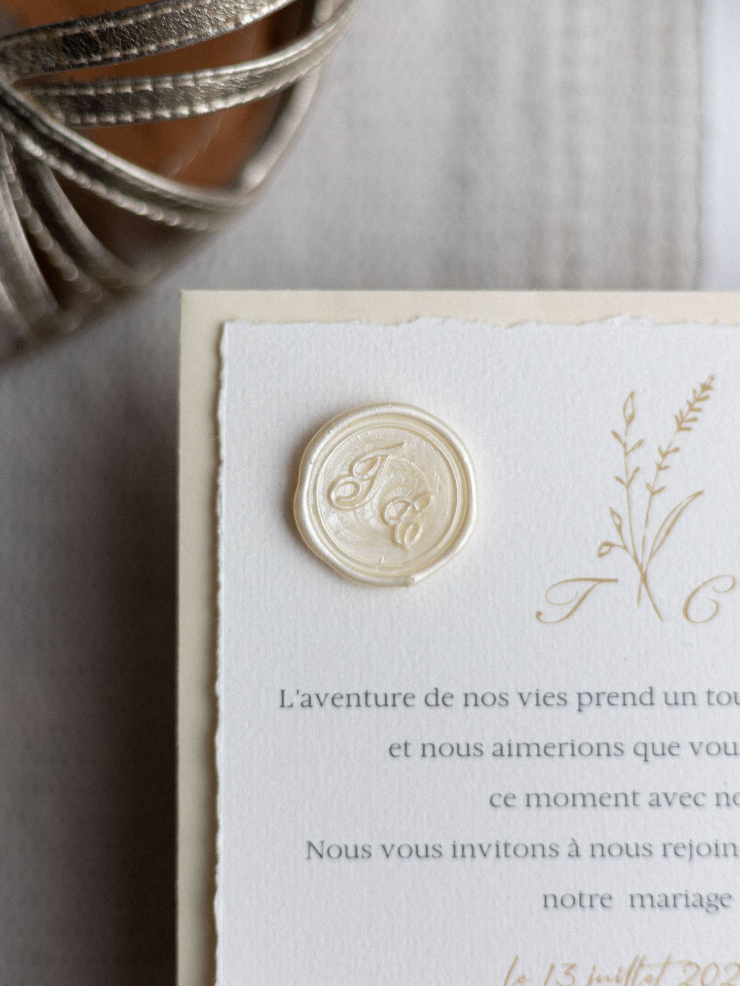 French wedding invitation with elegant wax seal and calligraphy details.