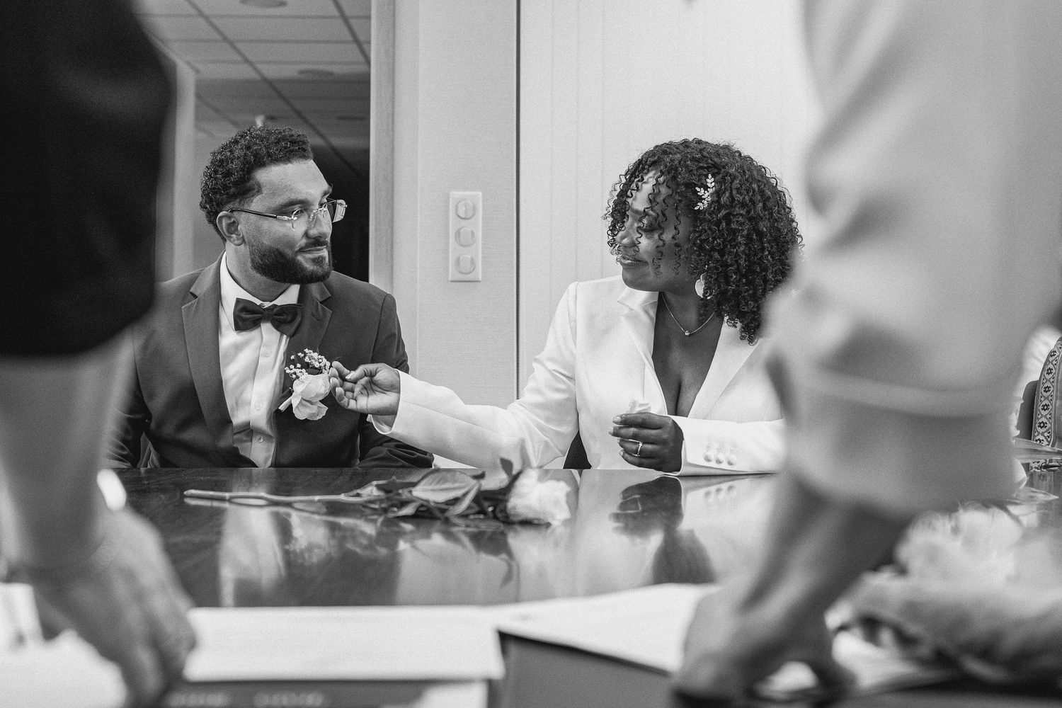Black and white sequence of people getting ready in a room with fluorescent lighting.