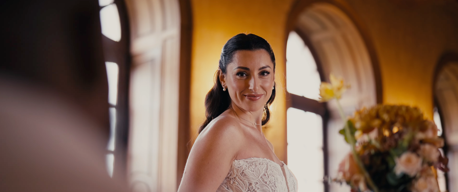 Wedding party members pose and celebrate during golden hour in an elegant venue setting.