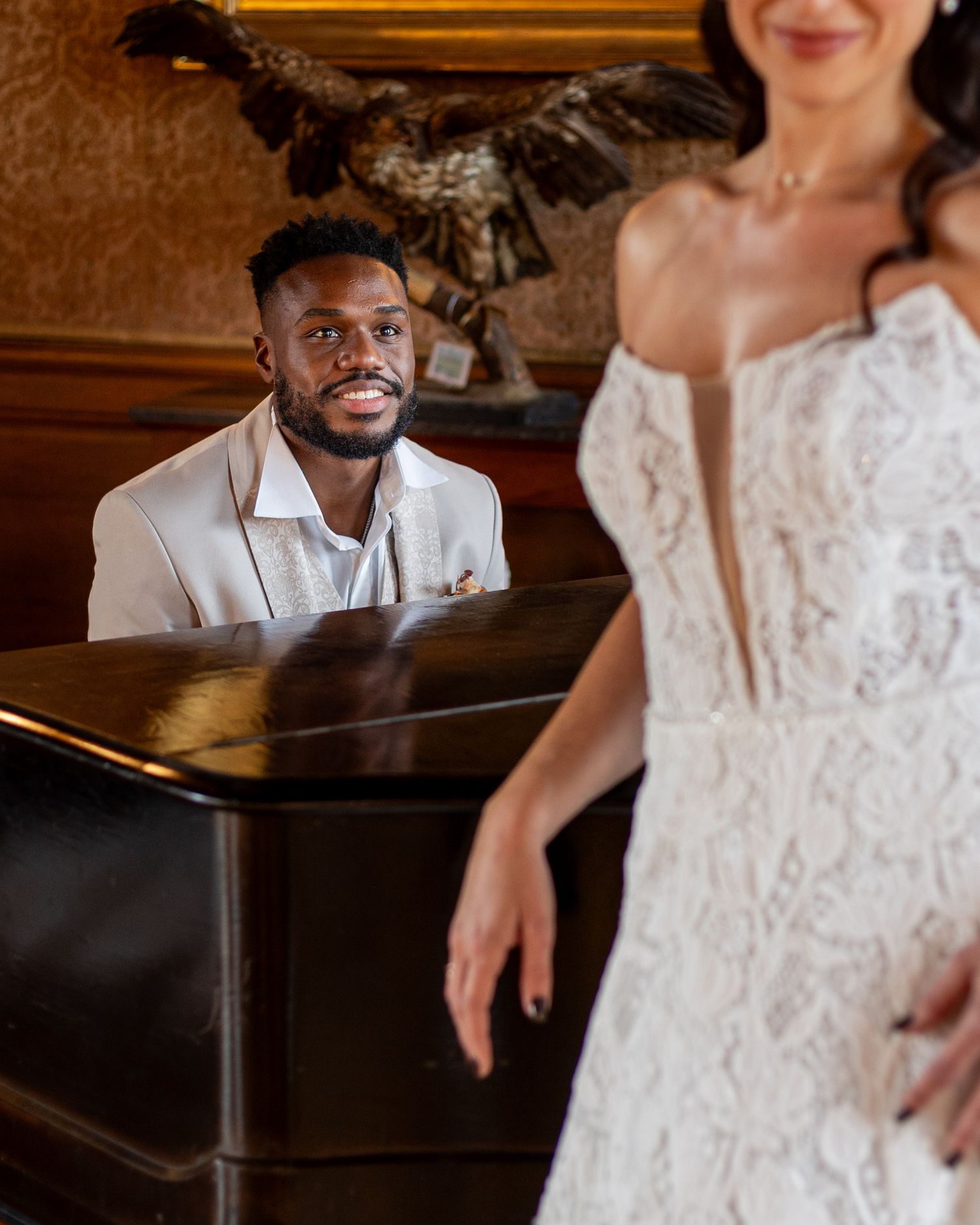 Couple sharing intimate first look moment in ornate vintage ballroom setting.