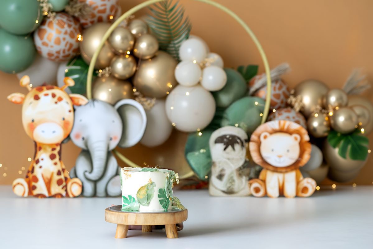 Festive Christmas scene with sage green and gold ornaments arranged with decorative woodland creatures and pine branches.