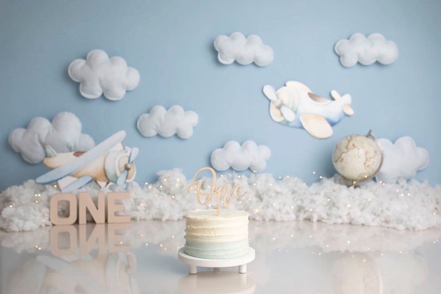A whimsical paper craft scene with white clouds, flying birds, and delicate decorative elements against a soft blue background.