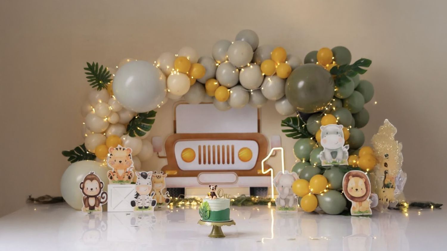 Safari themed baby shower display with plush animals, balloons, and decorative elements on a white shelf.