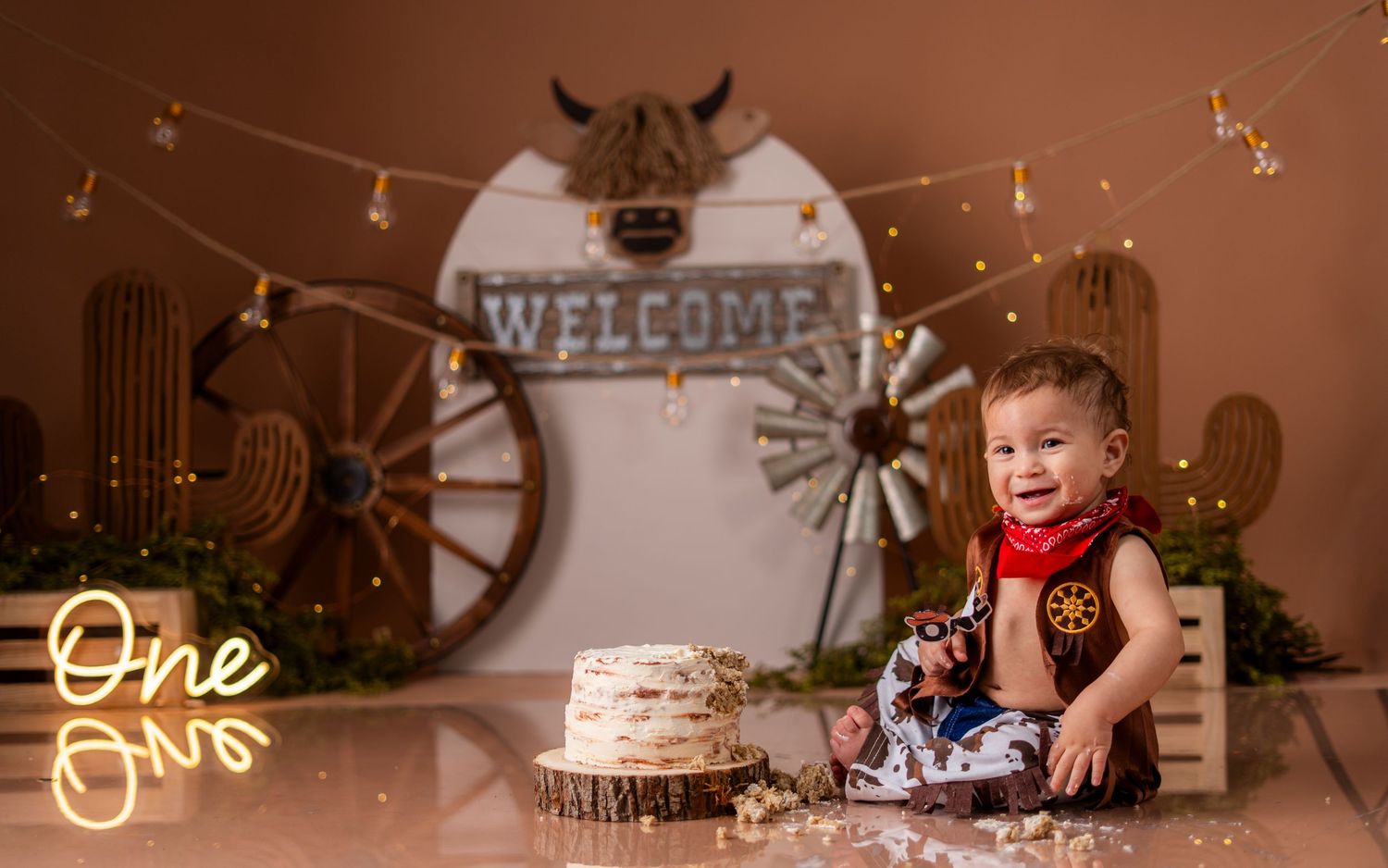 Rustic western themed birthday setup with string lights, cow skull decor, and welcome sign for celebration.