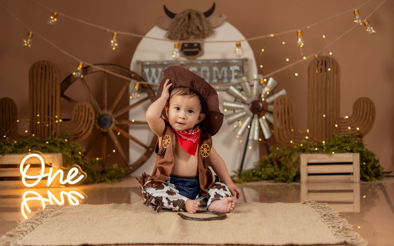 A rustic birthday setup with string lights, wooden crates, and welcome sign creating a cozy atmosphere.
