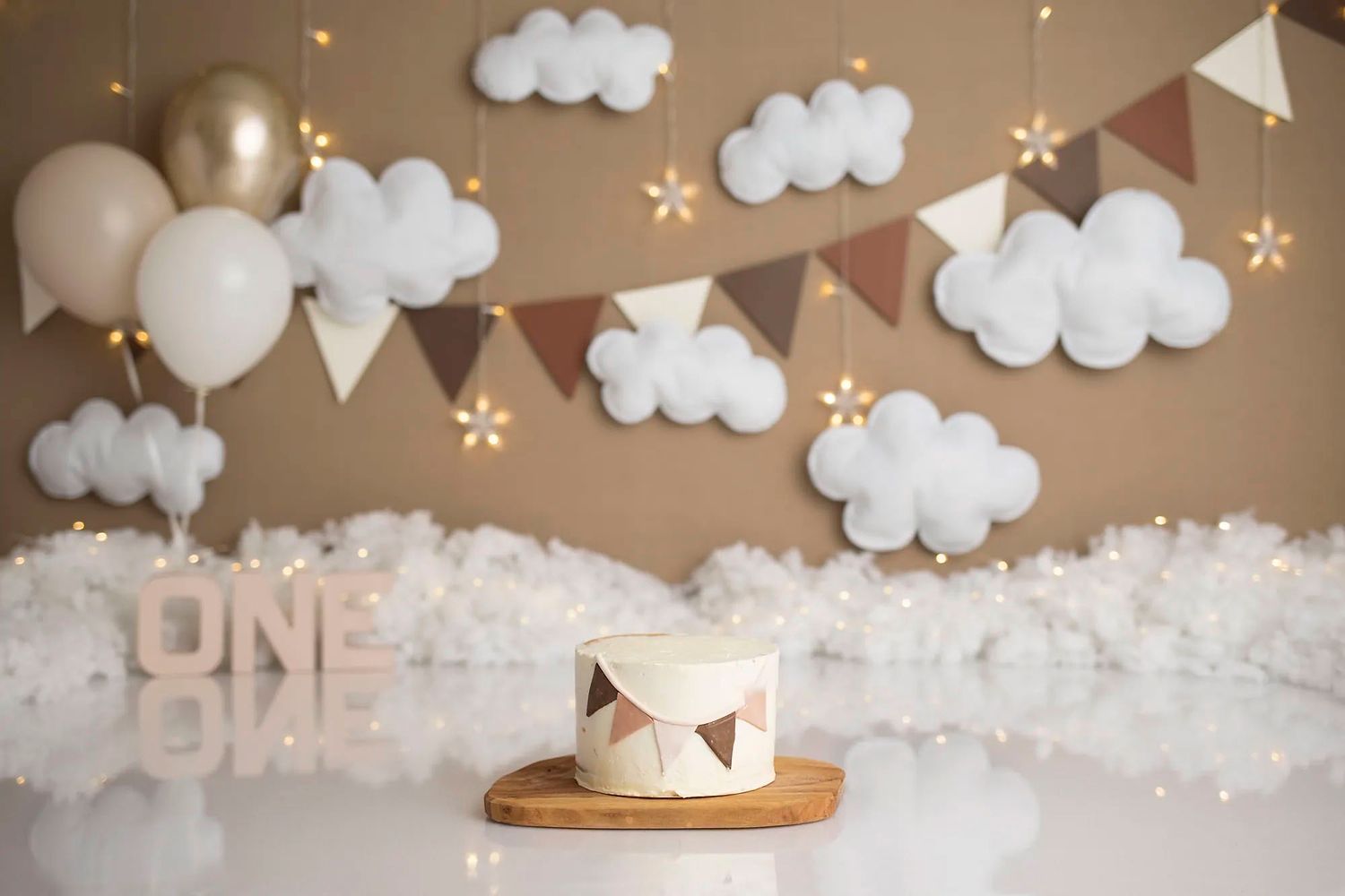 White cloud decorations and string lights create a dreamy party atmosphere with hanging stars and balloons.