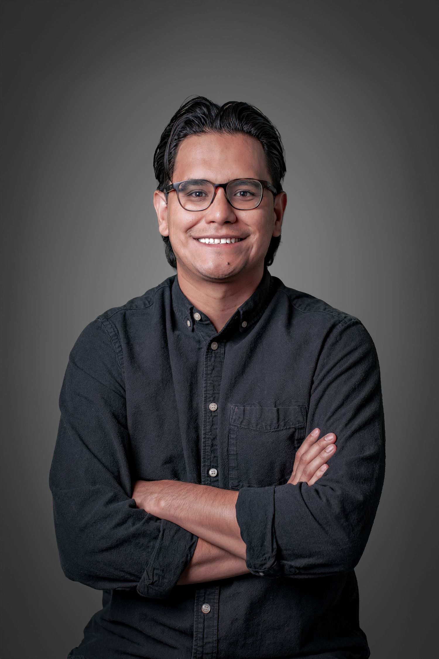 Professional headshot series showing a person in a black button-up shirt against a gray background with varying poses.